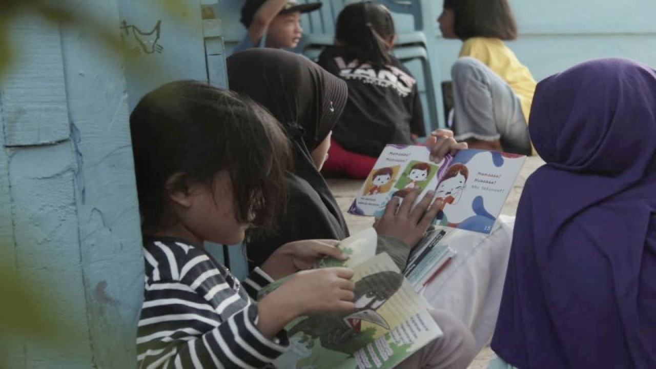 Sejumlah anak di Bandarlampung sedang membaca buku di Sekolah Rakyat Busa Pustaka di Bandarlampung, Minggu, (4/6/2023). (ANTARA/Dian Hadiyatna)