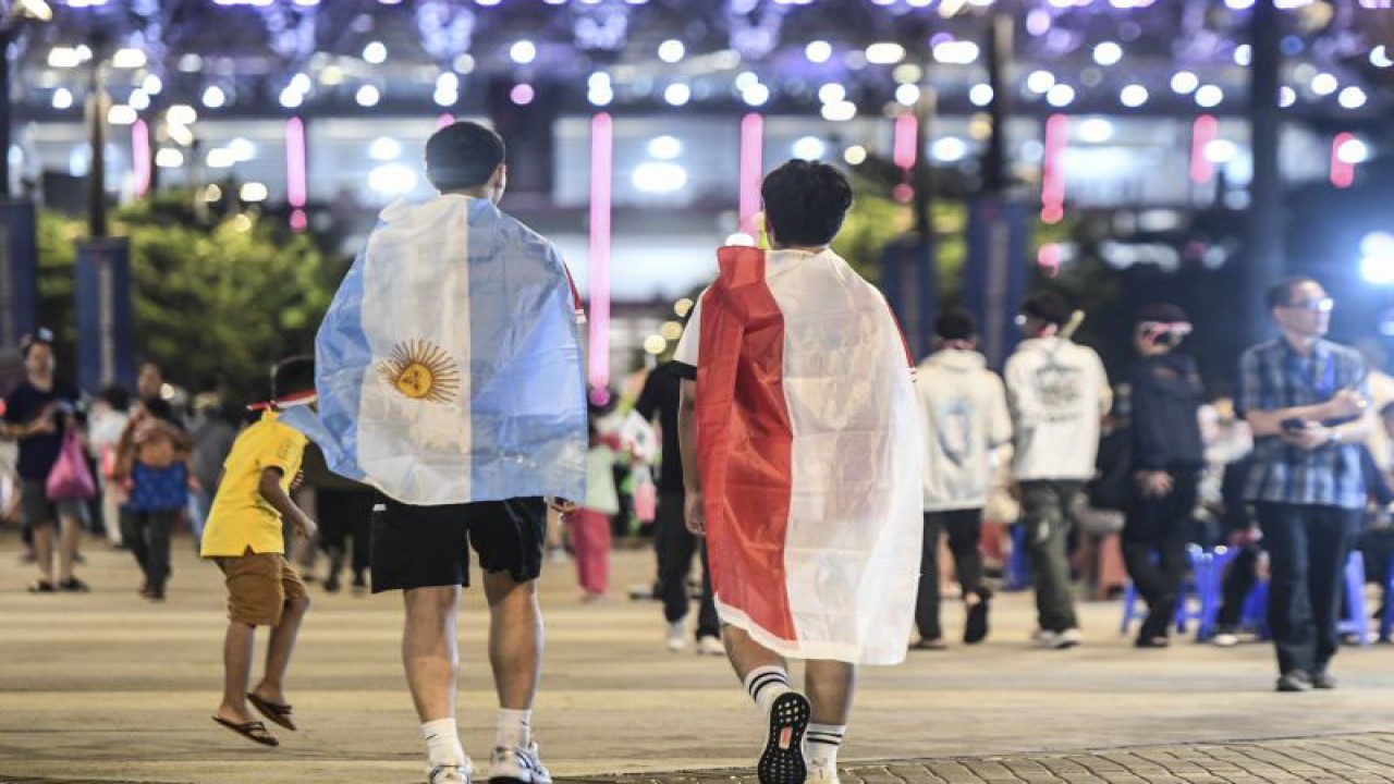 Penonton membawa bendera Merah Putih dan Bendera Argentina saat bersiap menyaksikan pertandingan sepak bola Timnas Indonesia melawan Timnas Argentina di Stadion Utama Gelora Bung Karno, Senayan, Jakarta, Senin (19/6/2023). Timnas Indonesia bertanding melawan Timnas Argentina pada laga FIFA Matchday. ANTARA FOTO/Hafidz Mubarak A/tom.
