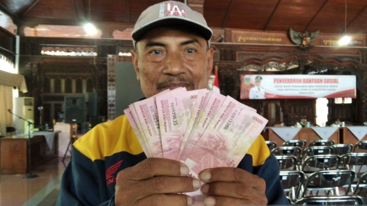 Seorang ahli waris menunjukkan uang bantuan santunan kematian yang diterima dari Pemerintah Kabupaten Kudus, Jawa Tengah, dipendopo Kabupaten Kudus, Jumat (23/6/2023). (ANTARA/Akhmad Nazaruddin Lathif)