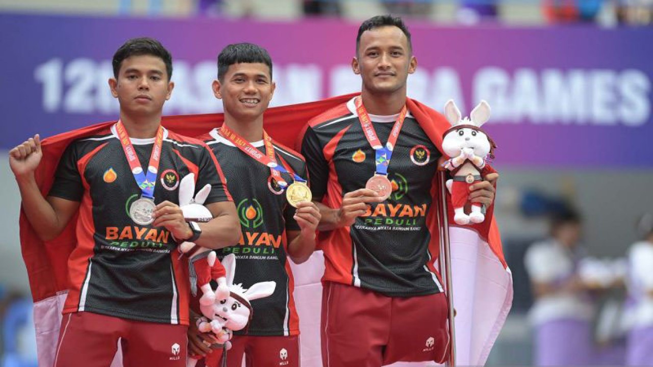 Tiga perenang putra Indonesia Jendi Pangabean (tengah) bersama Zaki Zulkarnain (kiri) dan Rino Saputra berpose dengan medali yang diraihnya pada nomor 100 meter gaya bebas S9 ASEAN Para Games 2023 Kamboja di Marodok Techo Aquatic Center, Phnom Penh, Kamboja, Minggu (4/6/2023). Jendi Pangabean berhasil meraih medali emas dengan catatan waktu 1 menit 00,59 detik disusul rekan senegaranya Zaki Zulkarnain meraih medali perak (1 menit 02,97 detik) dan Rino Saputra meraih medali perunggu (1 menit 04,46 detik). ANTARA FOTO/Zabur Karuru/aww.