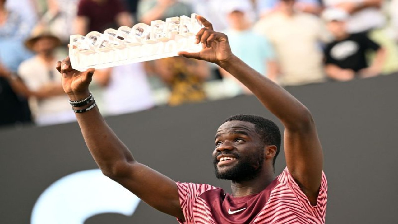 Petenis AS Frances Tiafoe merayakan kemenangan dengan trofi setelah memenangi Stuttgart Open pada final melawan petenis Jerman Jan-Lennard Struff di Klub Tenis Weissenhof, Stuttgart, Jerman, Minggu (18/6/2023). (ANTARA/REUTERS/Angelika Warmuth)