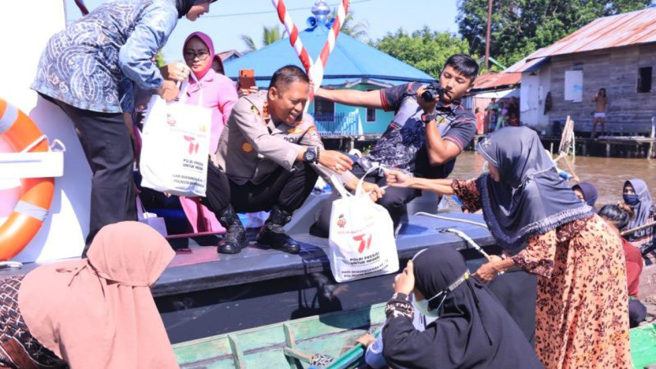 Kapolresta Banjarmasin Kombes Pol Sabana Atmojo saat membagikan paket sembako untuk masyarakat pesisir Sungai Martapura. (ANTARA/Firman)