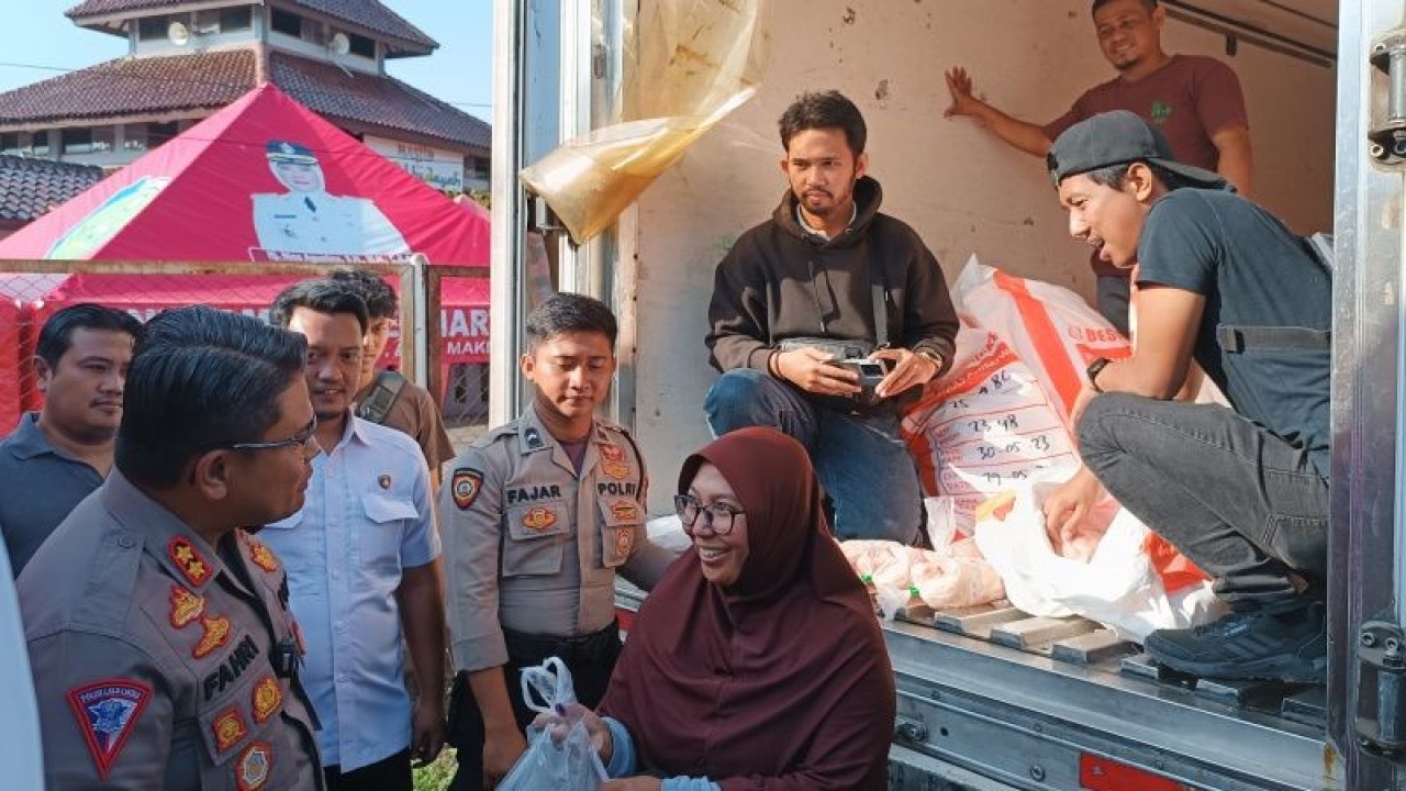 Kapolres Indramayu AKBP Fahri Siregar saat berinteraksi dengan warga yang membeli ayam potong saat bazar murah di Indramayu, Jawa Barat, Rabu (28/6/2023). (ANTARA/Khaerul Izan)