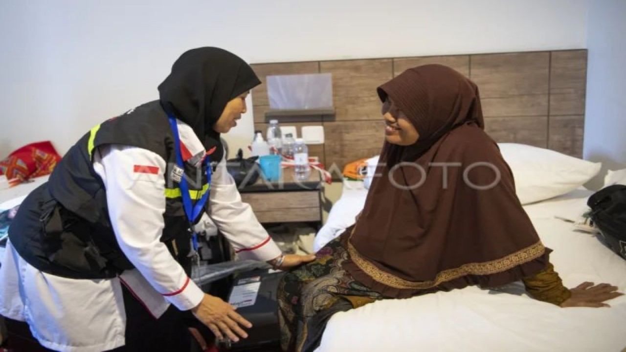 Konsultan ibadah PPIH Arab Saudi, Umi Musyarrofah (kiri), memberikan bimbingan kepada Sumiah (62), istri almarhum Suprapto yang merupakan jamaah pertama yang meninggal, di kamar hotel kawasan Mekkah, Arab Saudi, Senin (5/6/2023). (ANTARA FOTO/Wahyu Putro A/nym.)