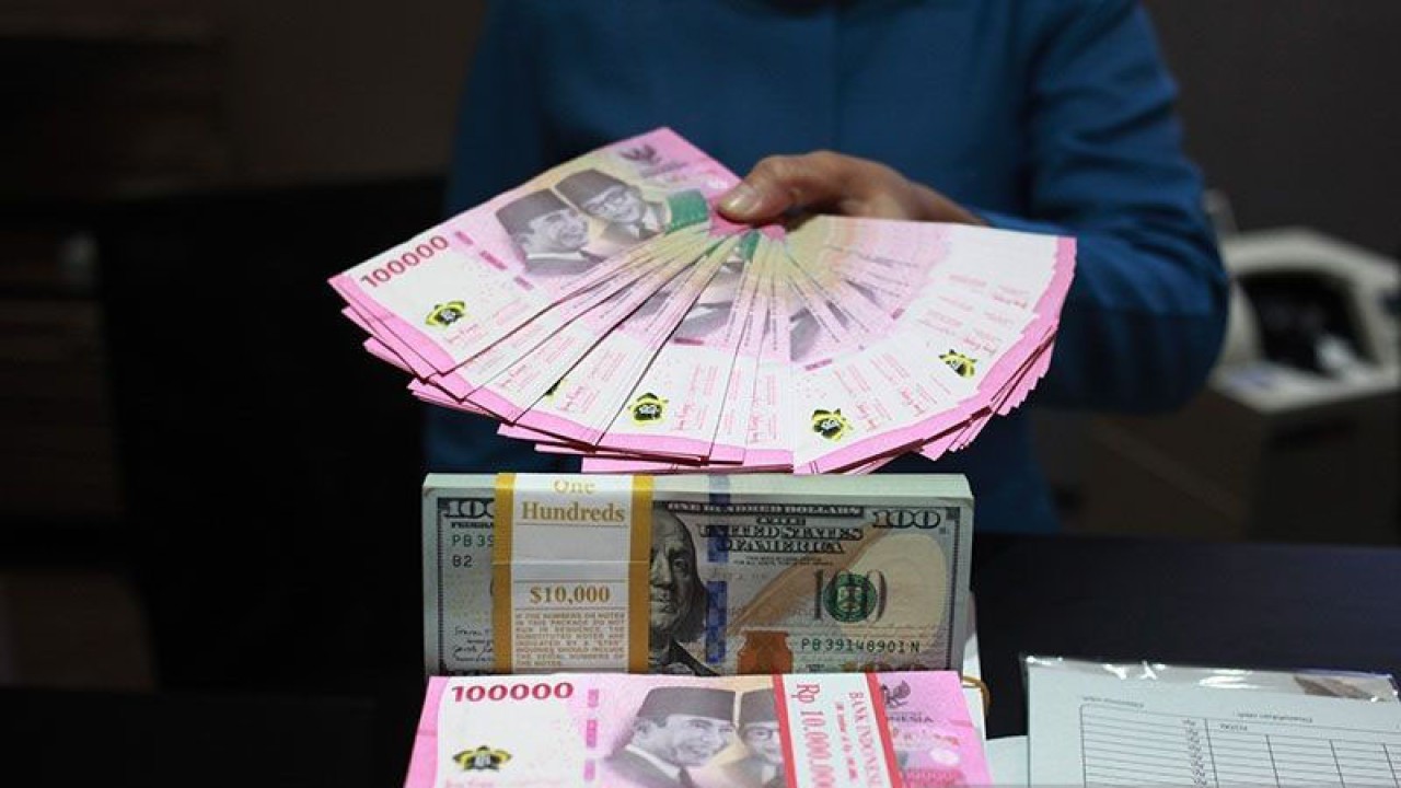 Arsip foto - Petugas menunjukkan uang dolar AS dan uang rupiah di salah satu kantor cabang PT. Bank Mandiri Persero Tbk, Jakarta.(ANTARA FOTO/Reno Esnir/tom/pri.)