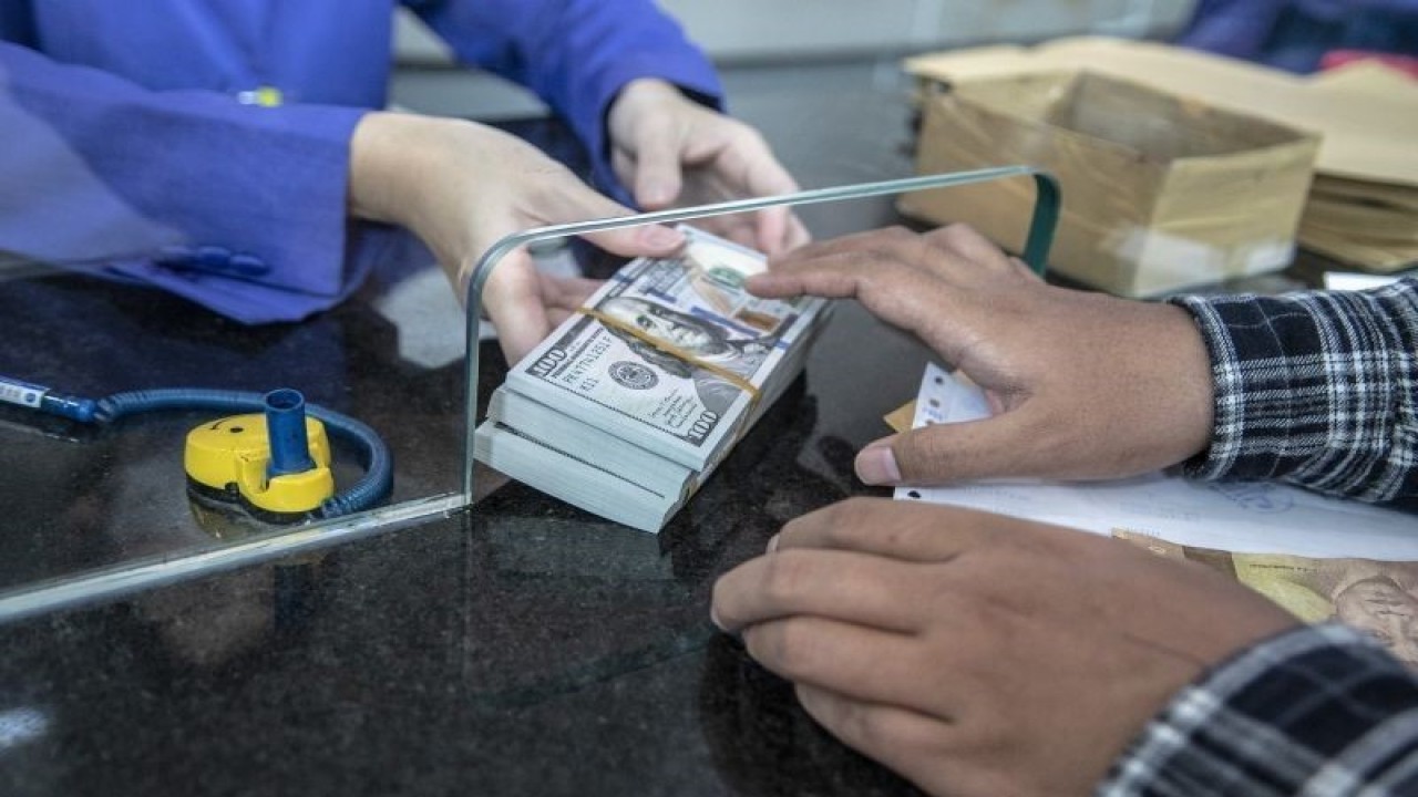 Petugas memberikan uang pecahan dolar AS kepada pembeli di gerai penukaran mata uang asing VIP (Valuta Inti Prima) Money Changer, Jakarta, Selasa (4/10/2022). ANTARA FOTO/Muhammad Adimaja/aww.