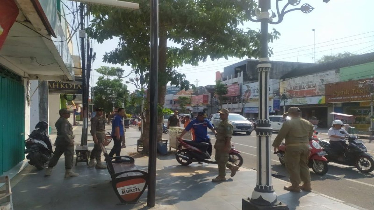 Petugas gabungan dishub dan Satpol PP Ponorogo saat menertikan kendaraan yang kedapatan parkir di atas trotoar di tepi jalur utama Kota Ponorogo, Jumat (16/6/2023) (ANTARA/HO - SDP)