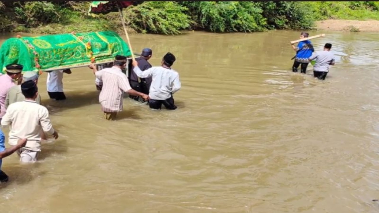 Sejumlah warga yang menyeberangkan jenazah melewati sungai di pesisir barat. (ANTARA/HO)