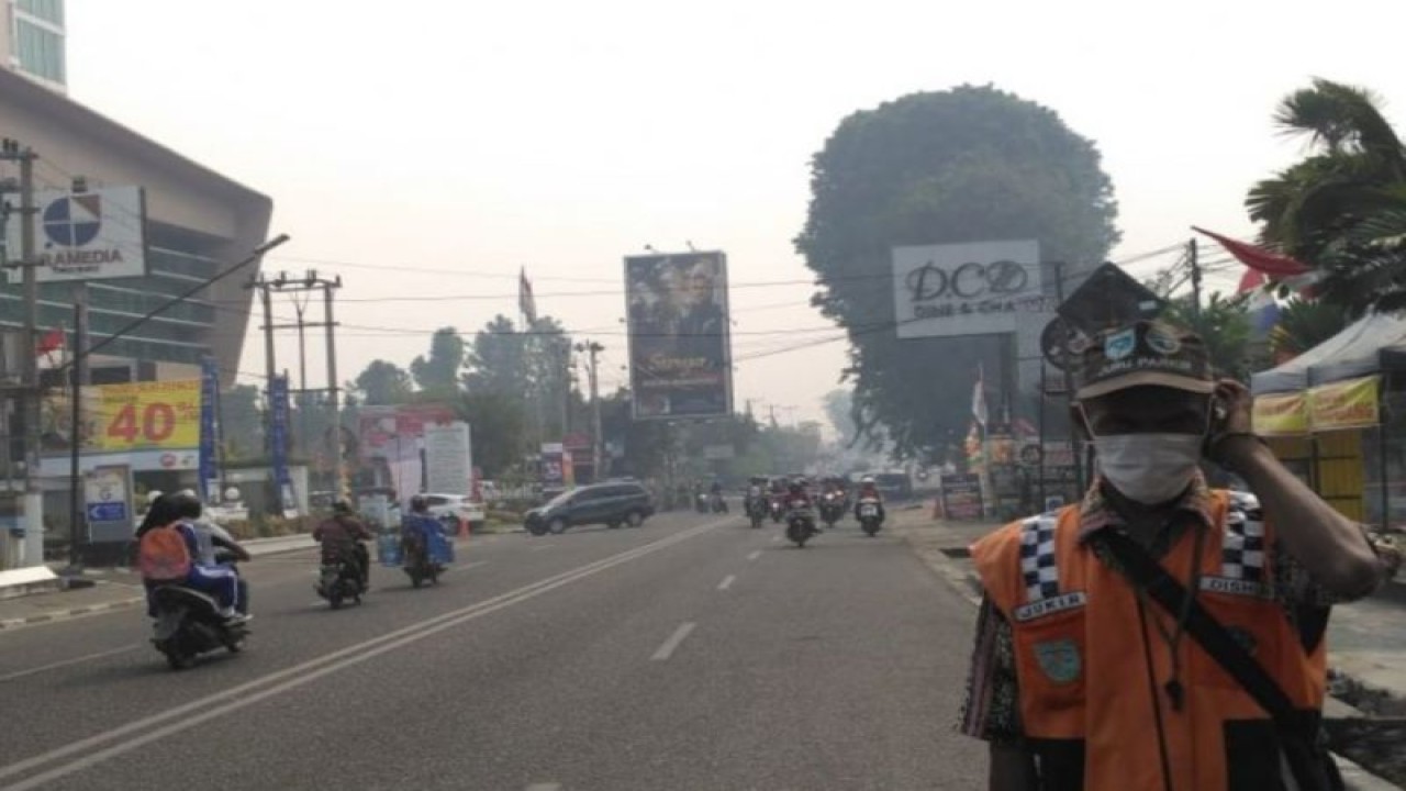 Seorang tukang parkir di Kota Jambi yang sedang mengatur parkir di jalan, Minggu (25/6/2023). (ANTARA/HO-IST)