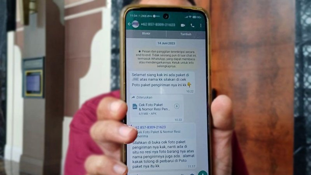 Seorang warga menunjukan pesan melalui aplikasi perpesanan yang diduga sebagai penipuan dengan modus 'sniffing". ANTARA/Dokumentasi