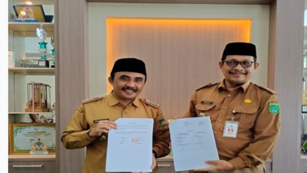 Kepala Dinas Kependudukan dan Pencatatan Sipil Kabupaten Tanah Bumbu Gento Hariyadi (kiri) dan Kepala Dinas Sosial Tanah Bumbu Basuni (kanan) usai penandatanganan nota kerja sama soal pelaksanaan Program Pelangsir Massal di Kabupaten Tanah Bumbu, Provinsi Kalimantan Selatan, Senin (5/6/2023). (ANTARA/HO-Diskominfo Tanah Bumbu)