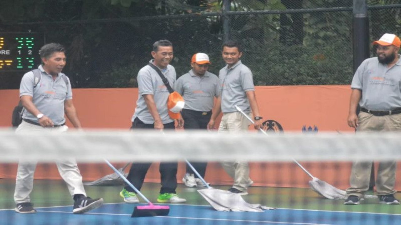 Para panitia mencoba mengeringkan lapangan tenis The Sultan Hotel & Residence Jakarta, arena pertandingan Harum Energy Men's World Tennis Tour 2023 setelah kawasan kawasan Gelora Bung Karno Senayan Jakarta diguyur hujan, Jumat (16/6/2023). (ANTARA/HO)