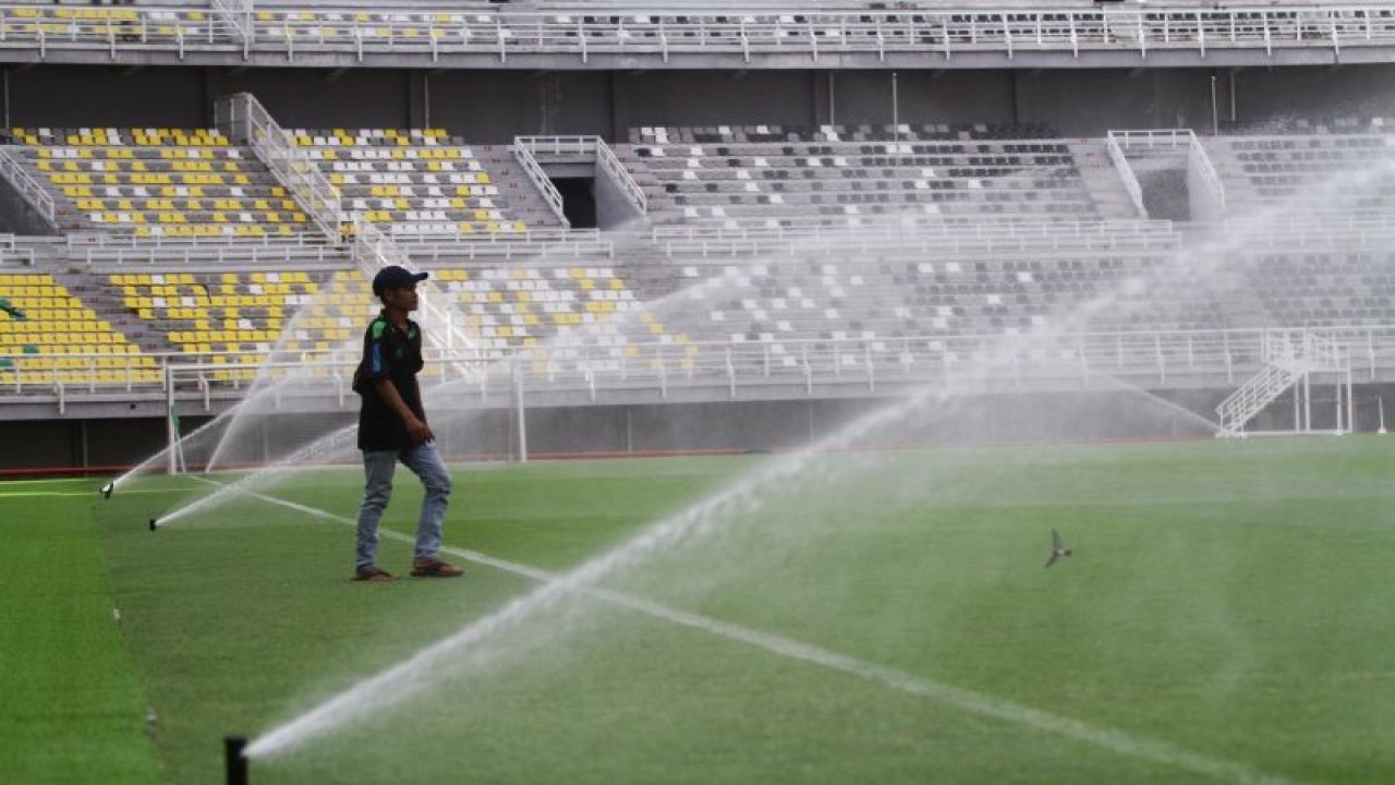 Pekerja mengawasi proses penyiraman lapangan di Stadion Gelora Bung Tomo, Surabaya, Jawa Timur, Minggu (11/6/2023). . ANTARA FOTO/Moch Asim/nz