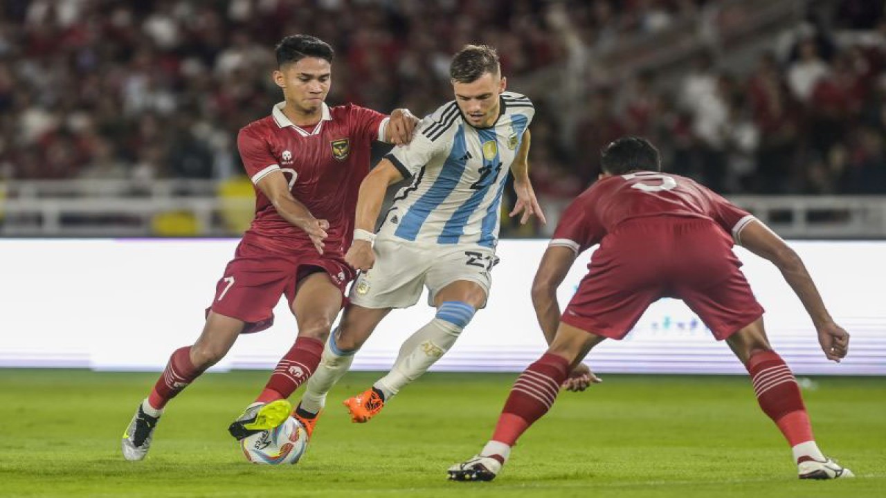 Pesepak bola Timnas Indonesia Ridho (kanan) dan Marselino (kiri) berusaha merebut bola dari pesepak bola Timnas Argentina Giovani Lo Celso (tengah) saat pertandingan FIFA Matchday di Stadion Utama Gelora Bung Karno, Jakarta, Senin (19/6/2023). ANTARA FOTO/GALIH PRADIPTA