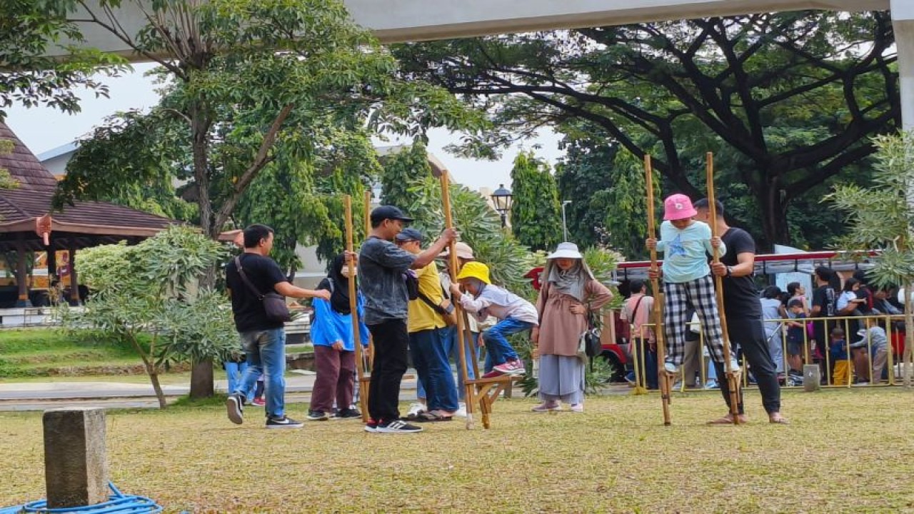 Sejumlah anak-anak tengah bermain egrang di pelataran taman yang disiapkan pengelola di Taman Mini Indonesia Indah (TMII), Jakarta Timur, Jumat (30/6/2023). Jumlah pengunjung di liburan panjang Hari Raya Idul Adha ini mencapai sekitar 10 ribu orang. ANTARA/HO-TMII