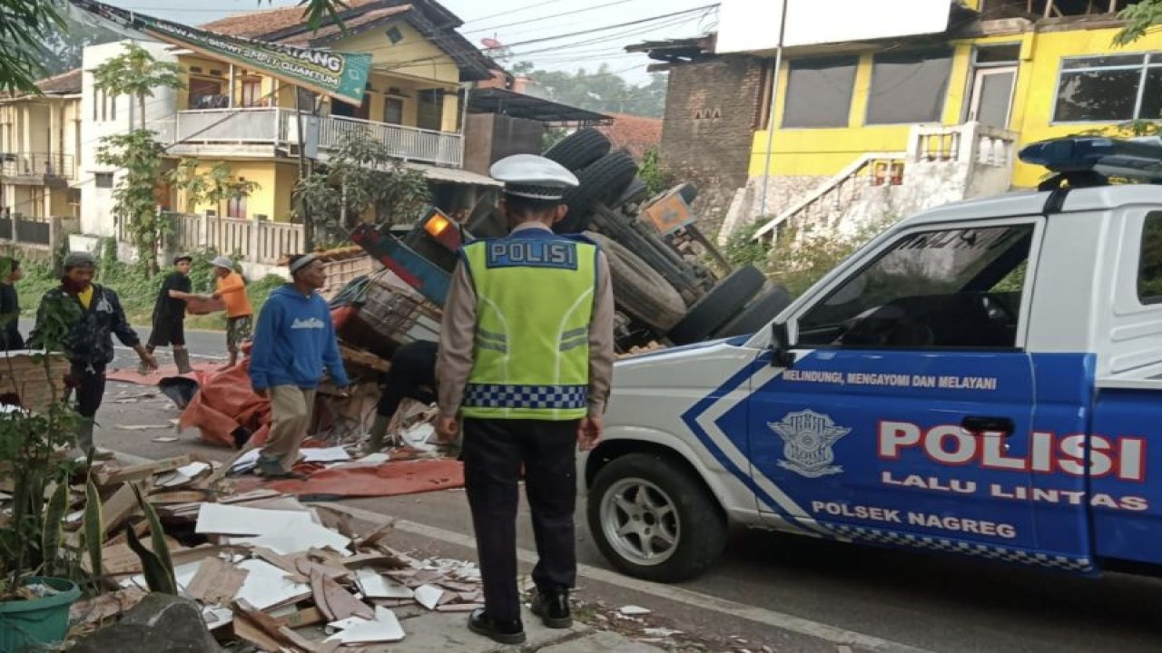 Polisi berupaya mengevakuasi truk terguling di kawasan Cagak Nagreg, Kabupaten Bandung, Jawa Barat, Senin (19/6/2023). (ANTARA/HO-Polsek Nagreg)