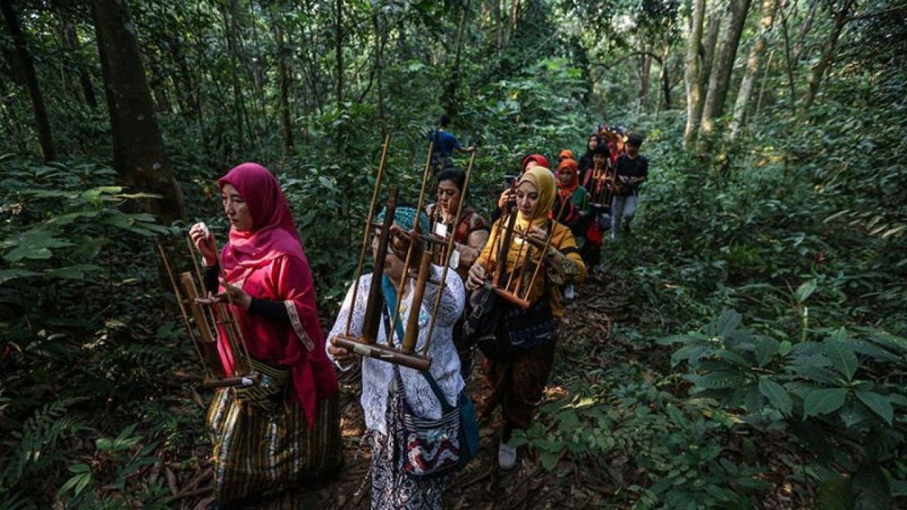 Peserta memainkan angklung dalam Kirab Sedekah Hutan di Hutan Universitas Indonesia, Depok, Jawa Barat, Sabtu (3/6/2023). (ANTARA FOTO/Asprilla Dwi Adha/rwa)