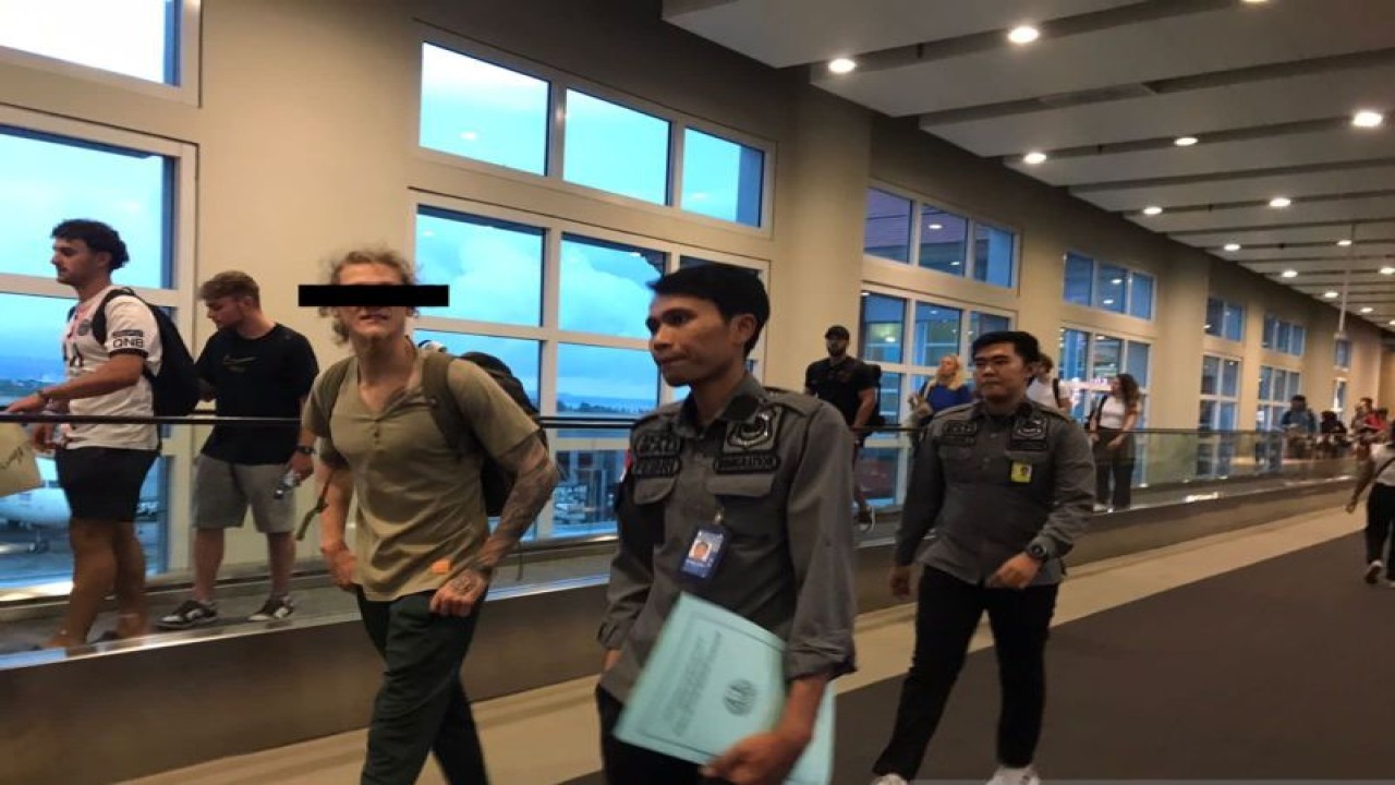 Petugas Rumah Detensi Imigrasi Denpasar mengawal seorang WNA Rusia (dua dari kanan) yang dideportasi ke Rusia karena merupakan eks narapidana kasus narkoba di Bandara Ngurah Rai, Bali, Selasa (6/6/2023) ANTARA/HO-Kemenkumham Bali