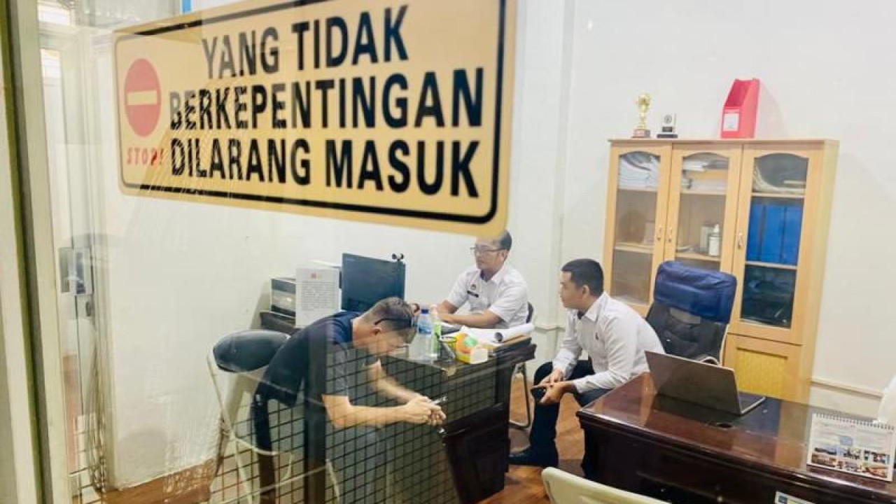 Petugas memeriksa seorang Warga Negara Asing (WNA) asal Australia, Risbi Jones Bodhi Mani (23 tahun) saat tiba di Kantor Imigrasi Kelas II Non TPI Meulaboh, Kabupaten Aceh Barat, untuk menunggu proses pemeriksaan sebelum dilakukan deportasi ke negara asalnya, Rabu (7/6/2023). (ANTARA/Teuku Dedi Iskandar)