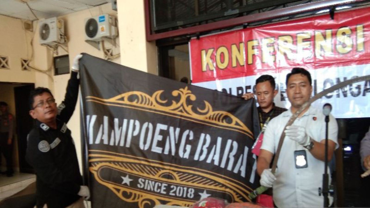 Kepala Satuan Reserse dan Kriminal AKP Sumaryono (berbaju putih) didampingi Kepala Seksi Huma Iptu Purno Utomo sedang membentang sebuah bendera Kampoeng Barat milik kelompok Kampoeng Barat sebagai barang bukti tindak pidana, di Pekalongan, Kamis (20/7/2023). (ANTARA/Kutnadi)