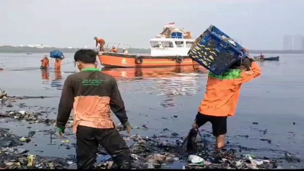 Sejumlah petugas Dinas Lingkungan Hidup gabungan dari Jakarta Utara dan Kepulauan Seribu mengangkut keranjang berisi sampah dari kawasan pesisir Hutan Mangrove Muara Angke, Penjaringan, Jakarta Utara, Rabu (12/7/2023). ANTARA/Abdu Faisal