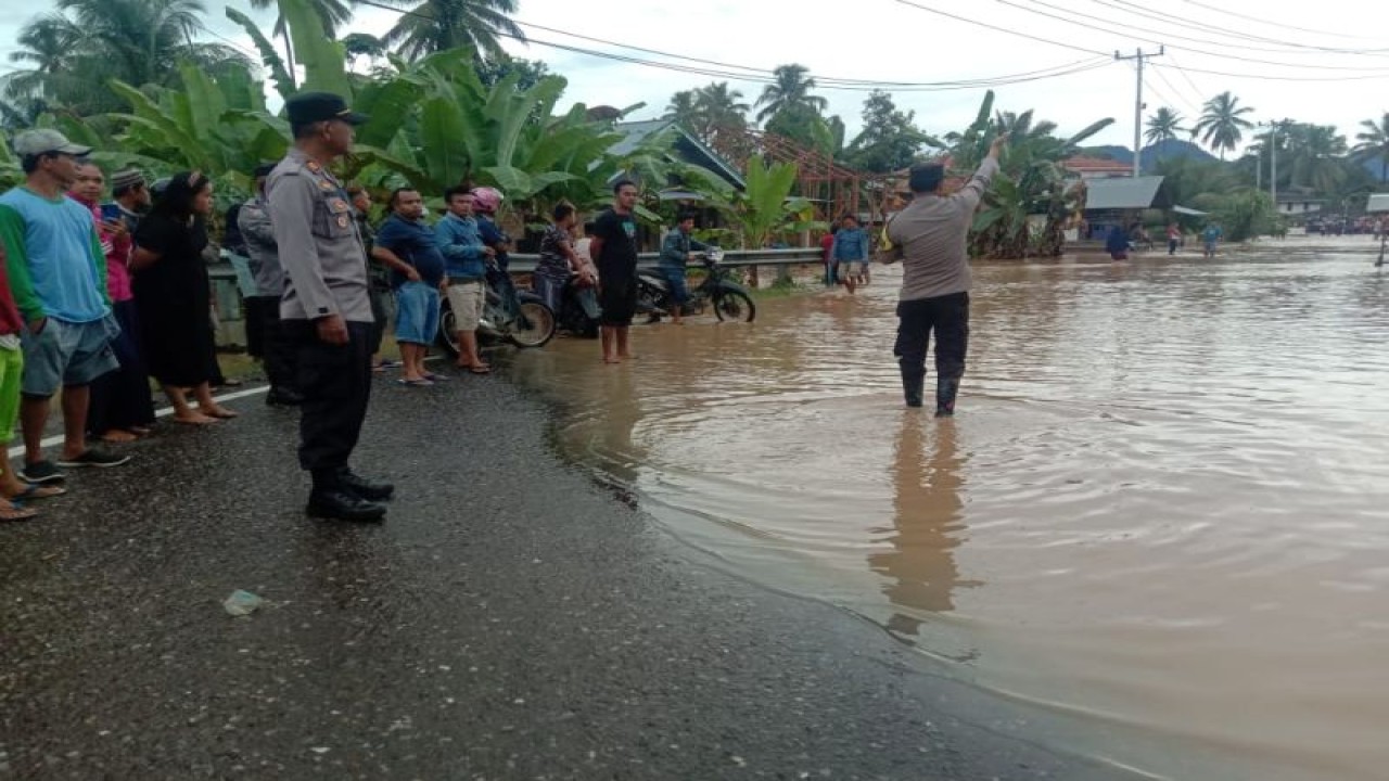 Personel Polres Pasaman Barat, Sumbar saat melakukan pemantauan dan memberikan bantuan kepada warga korban banjir Sungai Batang Saman di Nagari Aia Gadang Kecamatan Pasaman, Jumat (14/7/2023). FOTO ANTARA/Altas Maulana.