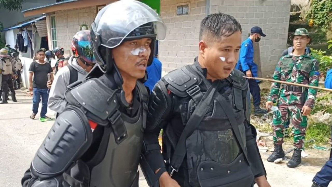 Brigpol Toto Harianto (kanan) terkena anak panah saat melakulan pengamanan penggusuran pemukiman liar di Kecamatan Batu Ampar, Kota Batam, Kepulauan Riau, Rabu (5/7/2023). (ANTARA/Ilham Yude Pratama)