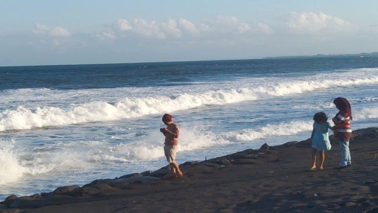 Arsip foto - Warga menikmati suasana pantai dengan ombak cukup tinggi di Pantai Purnama, Kabupaten Gianyar, Bali, Minggu (14/5/2023) ANTARA/Dewa Ketut Sudiarta Wiguna