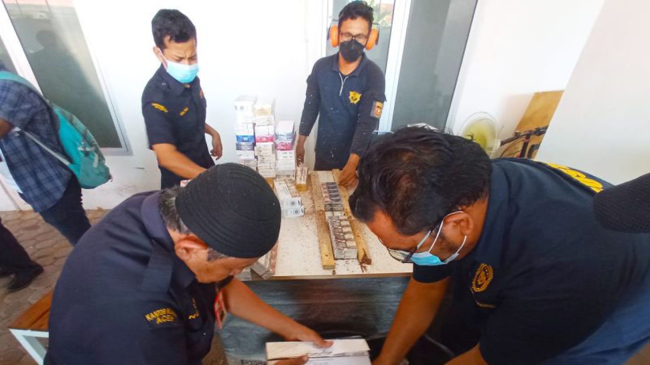 Petugas Bea Cukai Lhokseumawe melakukan pemusnahan barang bukti 1,1 juta batang rokok ilegal di halaman Kantor Bea Cukai Lhokseumawe, Kamis (6/7/2023). ANTARA/Dedy Syahputra.