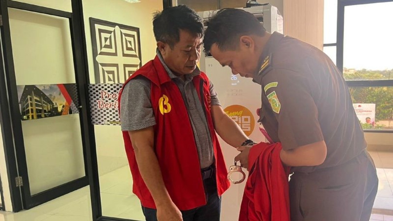 Petugas kejaksaan memasangkan borgol di tangan tersangka S usai menjalani pemeriksaan di Kantor Kejati NTB, Mataram, Selasa (25/7/2023) sore. ANTARA/HO-Kejati NTB