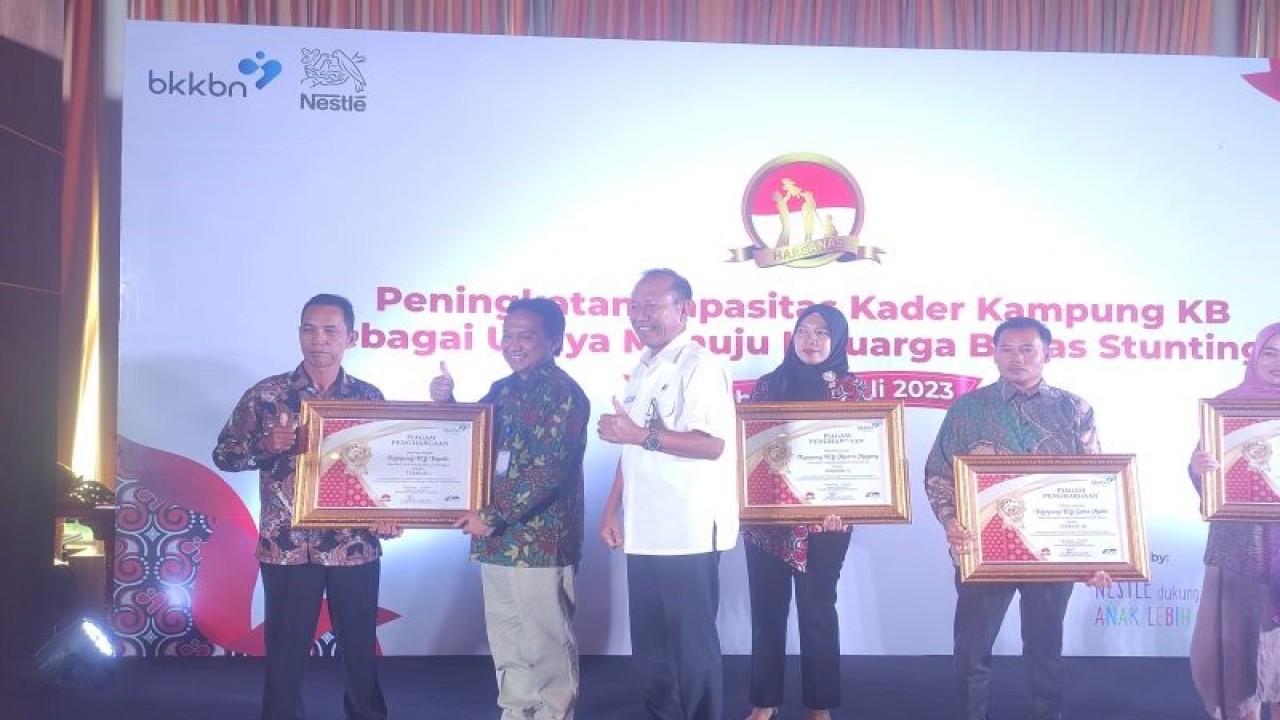Deputi Bidang Pengendalian Penduduk BKKBN RI Bonivasius Prasetya Ichtiarto memberikan plakat penghargaan kepada para pendamping pelaksanaan program Kampung KB, dalam acara Peningkatan Kapasitas Kader Kampung KB bersama Nesle DANCOW FortiGrow di Hotel Aston, Palembang, Sumatera Selatan, Rabu (5/7/2023). (ANTARA/M Riezko Bima Elko P)