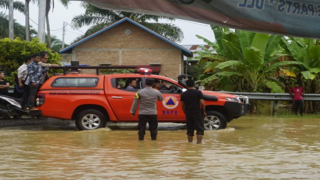 Wakil Bupati Pasaman Barat Risnawanto saat meninjau kondisi banjir di dekat Sungai Batang Saman, Jumat (14/7/2023). Antara/Altas Maulana.