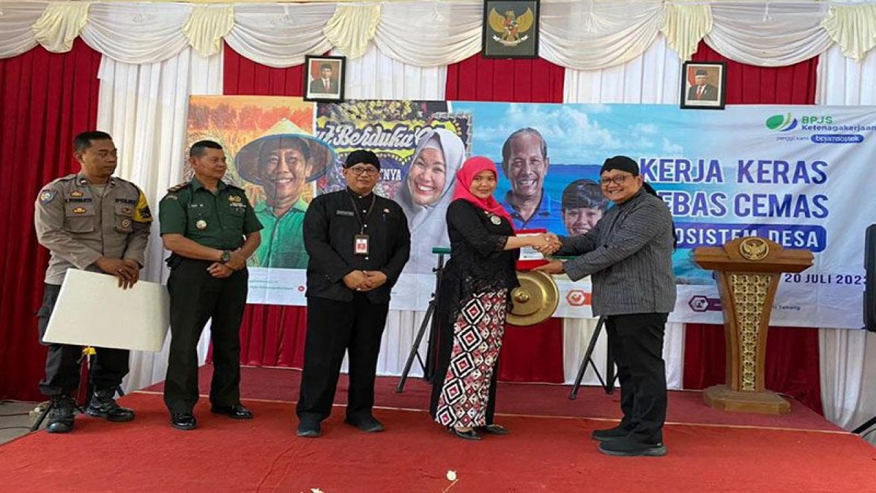 Kepala BPJAMSOSTEK Cabang Purwokerto Antony Sugiarto (kanan) menyerahkan cendera mata kepada Camat Gumelar Diah Rapitasari pada cara peluncuran program Kerja Keras Bebas Cemas (KKBC) Masuk Desa di Kecamatan Gumelar, Kabupaten Banyumas, Kamis (20/7/2023). ANTARA/HO-BPJAMSOSTEK Purwokerto