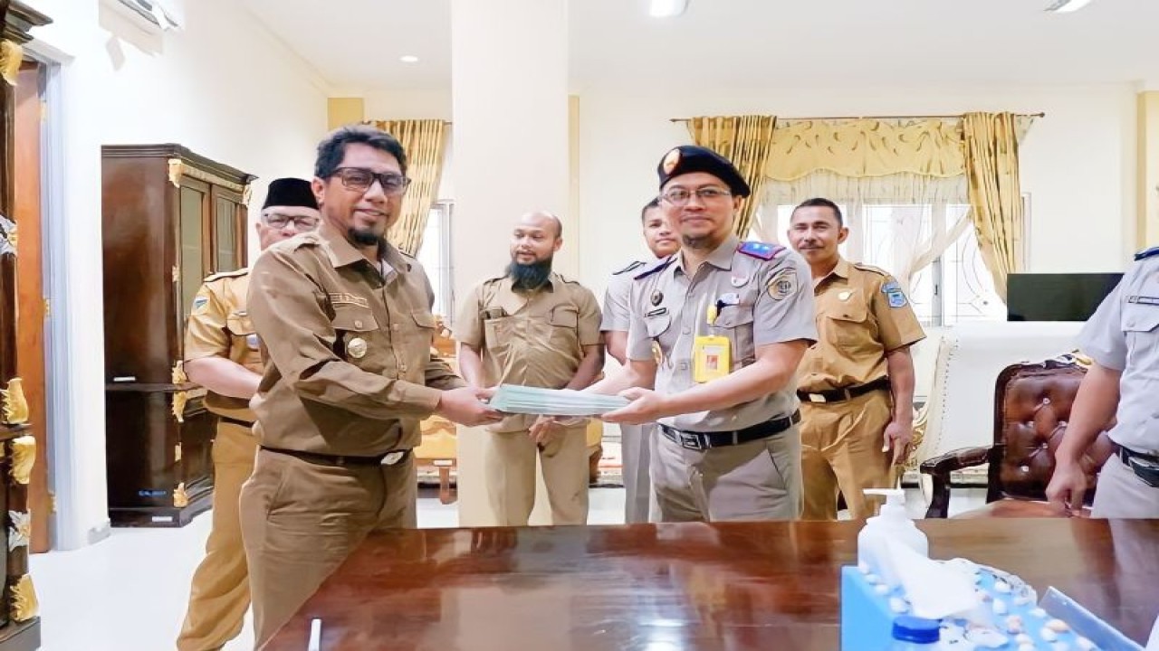 Bupati Bangkep Ihsan Basir dan Kepala BPN Bangkep Mardianto foto bersama sambil memperlihatkan sertifikat tanah dari BPN. (ANTARA/HO-Dinas Kominfo Kabupaten Bangkep)