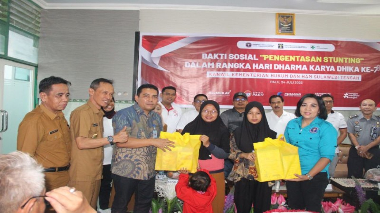 Kepala Kanwil (Kakanwil) Kemenkumham Sulteng Budi Argap Situngkir (ketiga kiri) memberikan paket sembako kepada salah satu peserta ibu hamil pada kegiatan baksos di Puskesmas Bulili, Palu, Senin (24/7/2023). (ANTARA/HO-Humas Kemenkumham Sulteng)
