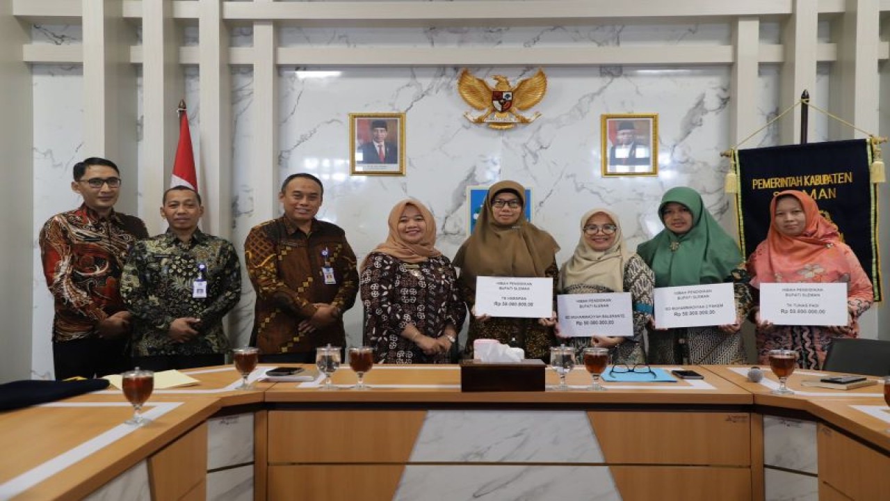 Bupati Sleman Kustini Sri Purnomo menyerahkan dana hibah pendidikan tahun 2023 kepada empat perwakilan sekolah di ruang rapat Bupati Sleman, Senin (24/7/2023). ANTARA/HO-Bagian Prokopim Setda Sleman