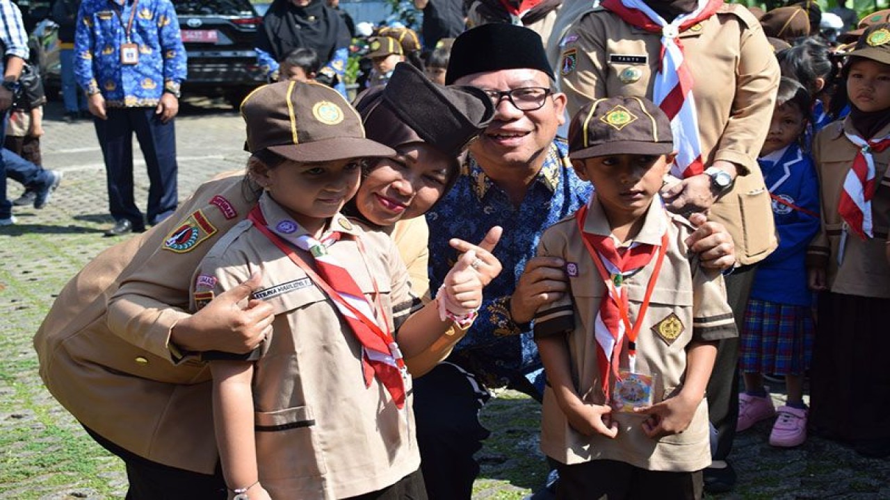 Bupati Banyumas Achmad Husein dan Bunda PAUD Banyumas Erna Sulistyawati Husein berfoto bersama dengan dua peserta didik TK usai peluncuran Pramuka Pra-Siaga Banyumas dalam rangkaian kegiatan Masa Pengenalan Lingkungan Sekolah (MPLS) tingkat PAUD dan TK di halaman TK Negeri Purwokerto Timur, Kabupaten Banyumas, Senin (17/7/2023). ANTARA/HO-Pemkab Banyumas