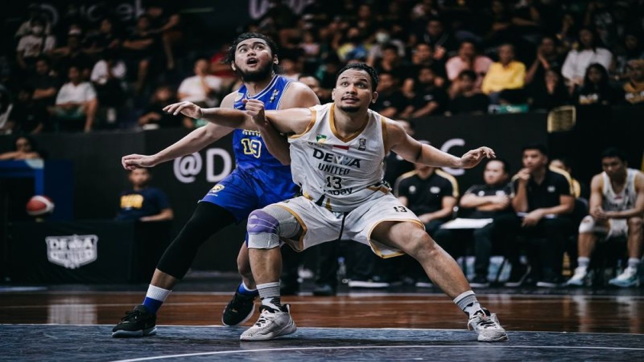 Pemain Dewa United Banten Kaleb Ramot Gemilang (kanan) dijaga oleh pemain Prawira Harum Bandung Reza Guntara (kiri) dalam laga semifinal IBL 2023 di Sritex Arena Solo, Kamis (13/7/2023). ANTARA/HO-IBL