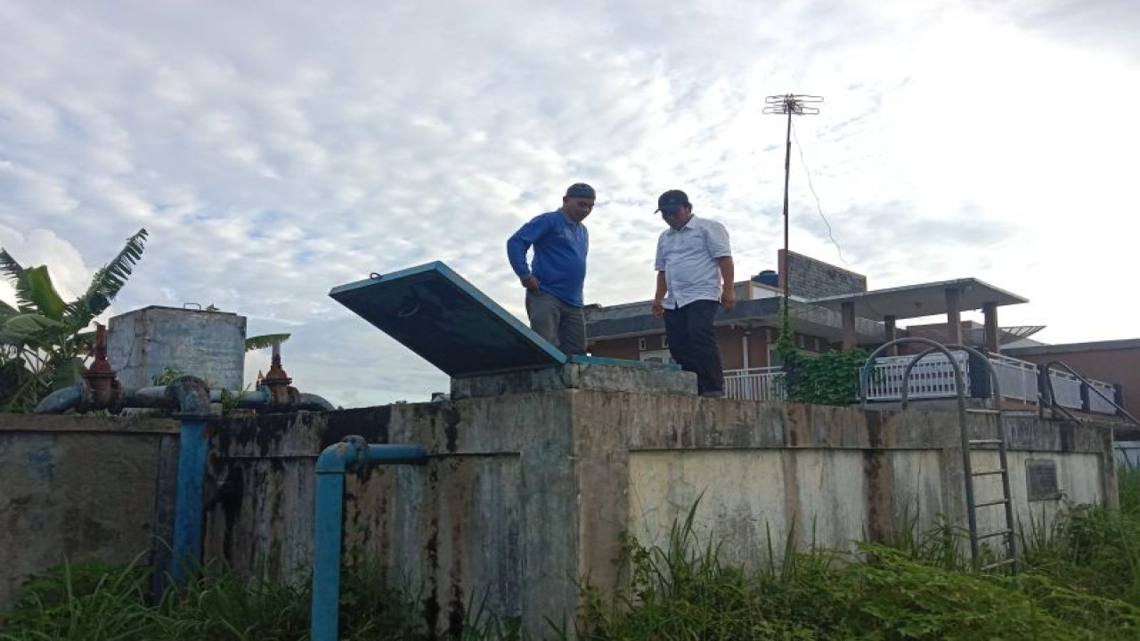 Direktur PDAM Tirta Antokan Agam Hendri Chaidir (kanan) sedang maninjau bak penampung di Kecamatan Baso. (Antara/Altas Maulana).