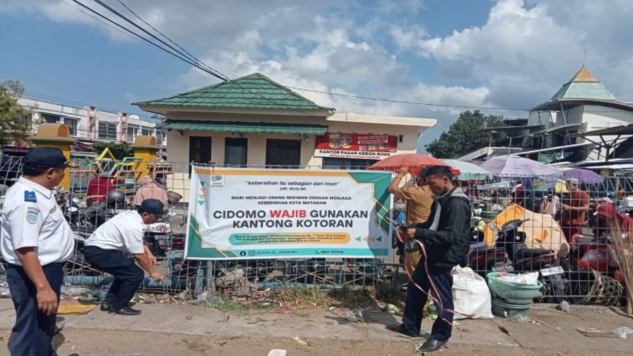 Pemasangan spanduk sosialisasi bagi kusir cidomo yang diwajibkan menggunakan kantong kotoran kuda saat beroperasi oleh petugas Dinas Perhubungan Kota Mataram, Provinsi Nusa Tenggara Barat, di Pasar Kebon Roek Ampenan. Senin (31/7-2023) (ANTARA/HO-dokumen pribadi)