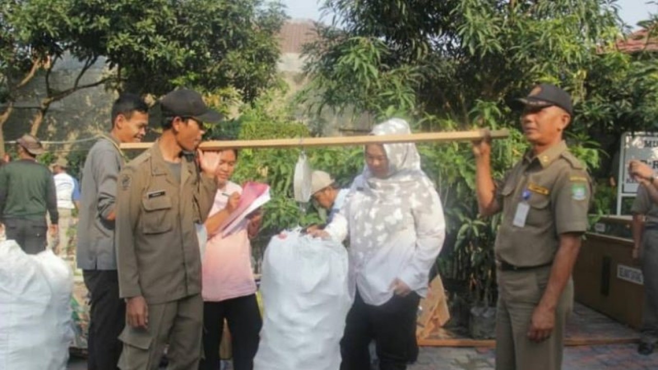 Warga sedang mencatat hasil timbangan jumlah sampah yang disetorkan ke Bank Sampah, Perlu diktehaui, Pemkot Tangerang mengulirkan program bank sampah dalam mengurangi jumlah buangan ke TPA dan pengelolaan di sumber. ANTARA/Irfan