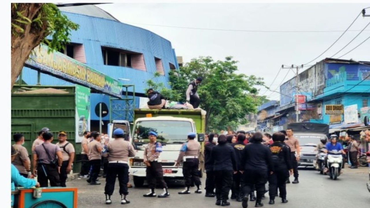 Anggota Polisi lakukan aksi kebersihan di kawasan pasar/pertokoan Jalan Ujung Murung Banjarmasin, Kamis (13/7/2023). (ANTARA/Syamsuddin Hasan)