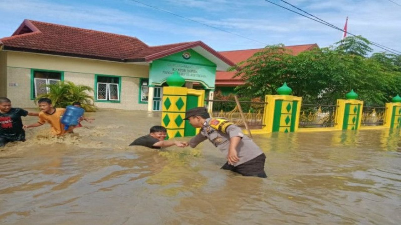 Personel kepolisian di Kabupaten Kolaka saat mengevakuasi anak-anak terendam banjir di Kolaka, Selasa (4/7/2023). ANTARA/HO-Humas Polres Kolaka
