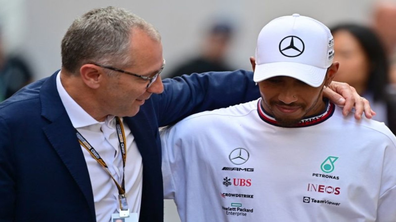 Ilustrasi - Formula One Group CEO Stefano Domenicali (L) speaks with Mercedes' British driver Lewis Hamilton after the Monaco Formula 1 Grand Prix at the Monaco street circuit in Monaco, on May 29, 2022. (Photo by ANDREJ ISAKOVIC / AFP) (AFP/ANDREJ ISAKOVIC)