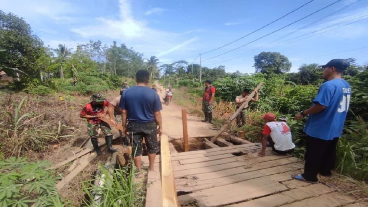 Prajurit Satgas Pamtas Yonarmed 16/TK bersama warga gotong royong memperbaiki jembatan rusak di Desa Temajuk perbatasan Indonesia-Malaysia, wilayah Sambas Kalimantan Barat. ANTARA/HO-Yonarmed 16/TK. (Teofilusianto Timotius)