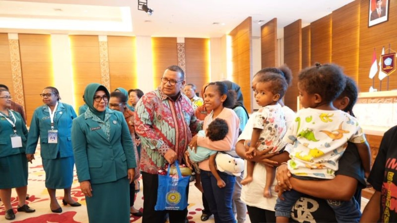 Penjabat Gubernur Papua Barat Daya Muhammad Musa'ad didampingi Ketua Tim Penggerak PKK Provinsi Papua Barat Daya Andar Aryani memberikan makanan pendamping ASI berbahan lokal kepada anak-anak di Aimas Convention Center, Kabupaten Sorong, Jumat (21/7/2023). (ANTARA/Yuvensius Lasa Banafanu)