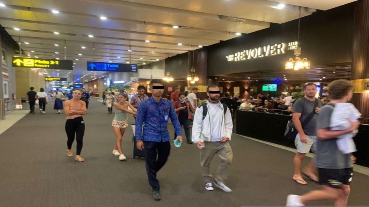 Kantor Imigrasi di Bali mendeportasi seorang warga negara asing (WNA) asal Amerika Serikat (tiga dari kanan) karena nekat mengadang dan merusak mobil dinas Polri di Bandara Ngurah Rai, Bali, Selasa (11/7/2023) ANTARA/Kemenkumham Bali
