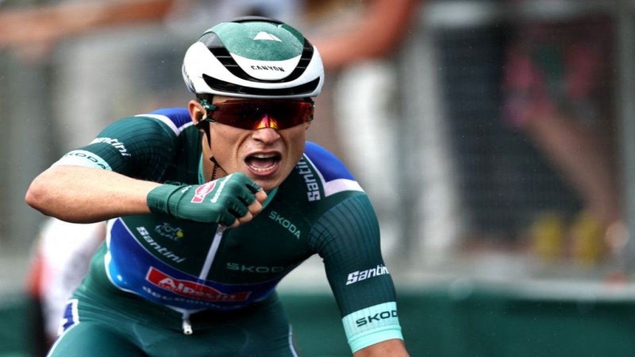 Pebalap tim Alpecin-Deceuninck Jasper Philpsen asal Belgia melakukan selebrasi setelah melintasi finis etape 11 Tour de France, menempuh 180km antara Clermont-Ferrand ke Moulins, Prancis tengah. (12/7/2023) (AFP/ANNE-CHRISTINE POUJOULAT)