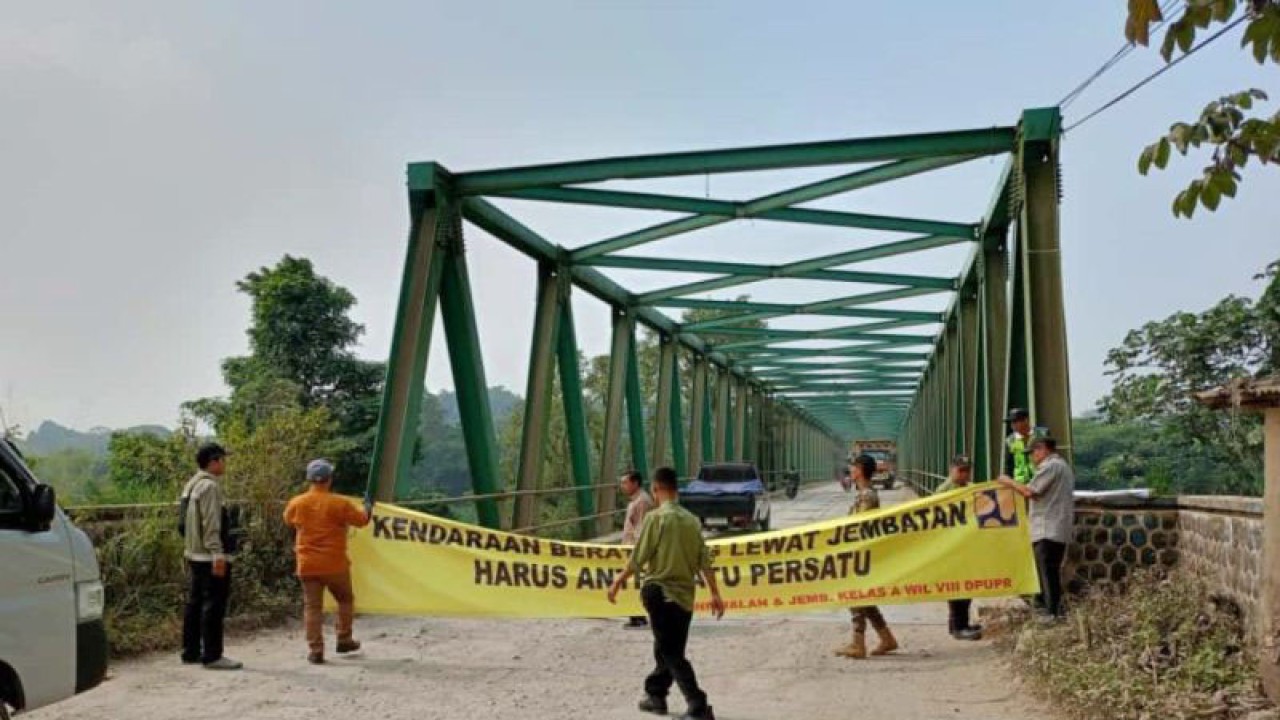 Pemasangan spanduk peringatan di Jembatan Leuwiranji, Kabupaten Bogor, Jawa Barat, Selasa (25/7/2023). (ANTARA/M Fikri Setiawan)