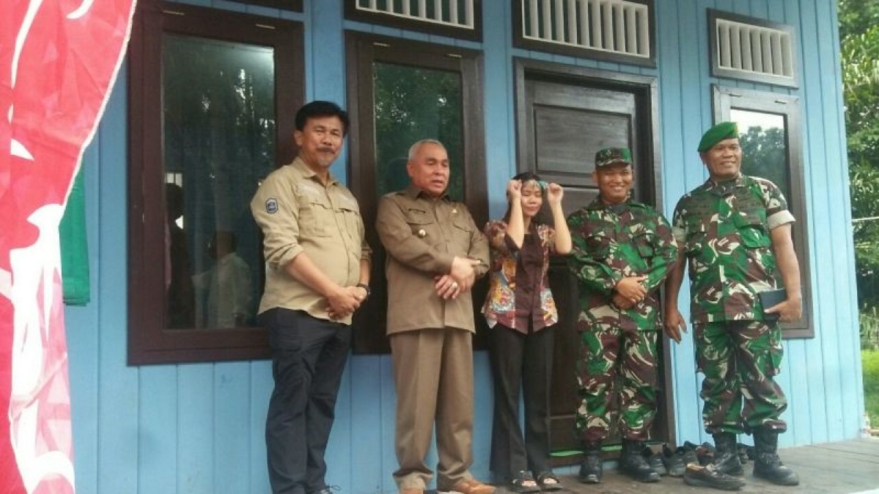 Gubernur Kalimantan Timur Isran Noor (dua dari kiri) bersama pejabat pemerintah terkait berfoto di depan rumah layak huni milik warga yang sudah selesai dibangun di Desa Kelakat, Kecamatan Kembang Janggut, Kabupaten Kutai Kartanegara, Provinsi Kalimantan Timur, Selasa (4/7/2023). (ANTARA / M Ghofar)